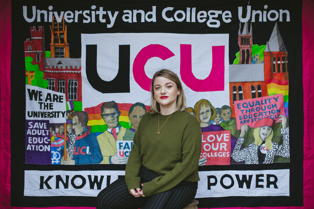 Jo sits in front of the UCU banner