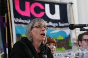 Ann Gow speaking into a microphone in front of a UCU banner