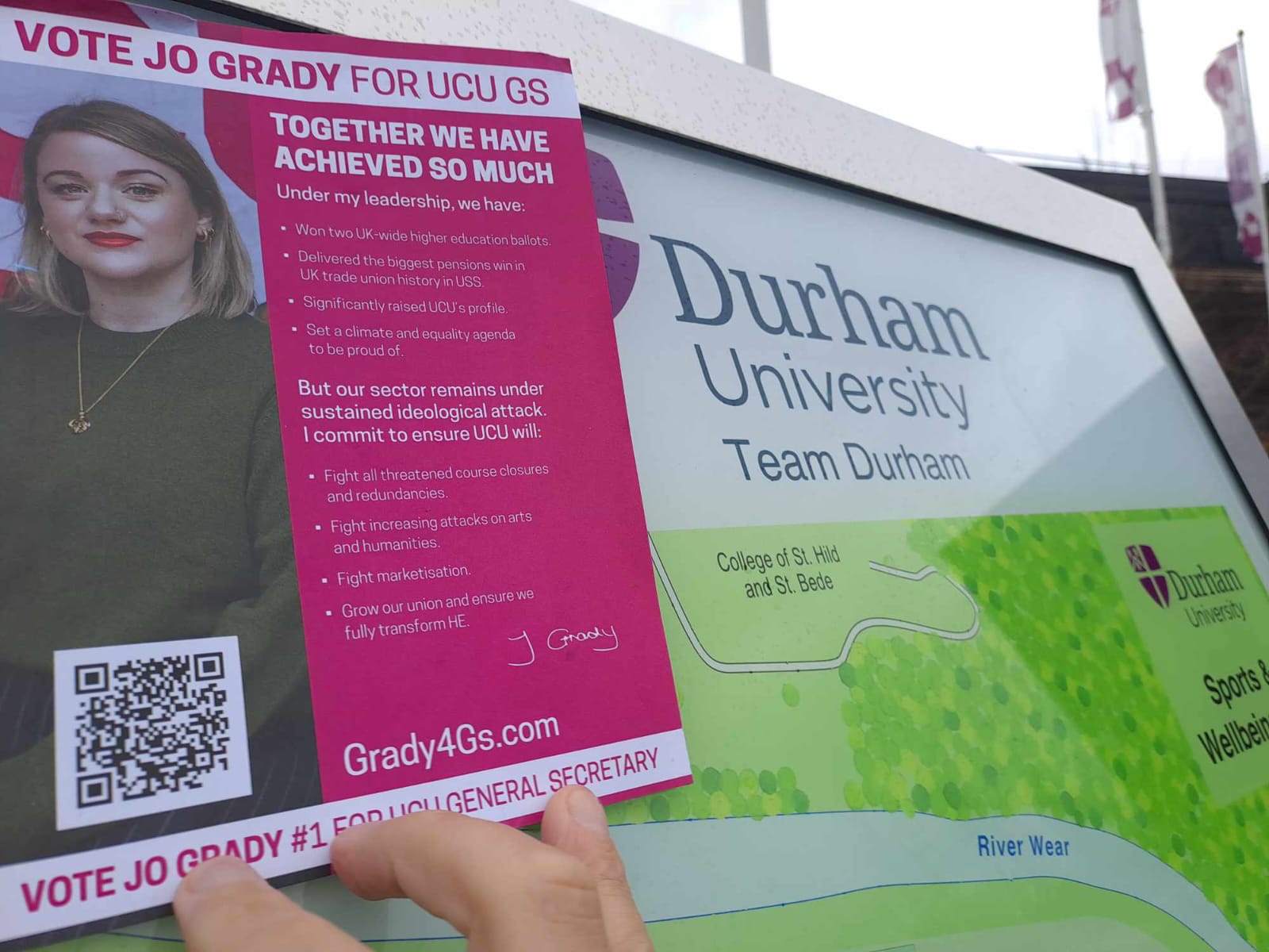 Grady4GS leaflet being held up next to a large map of Durham University